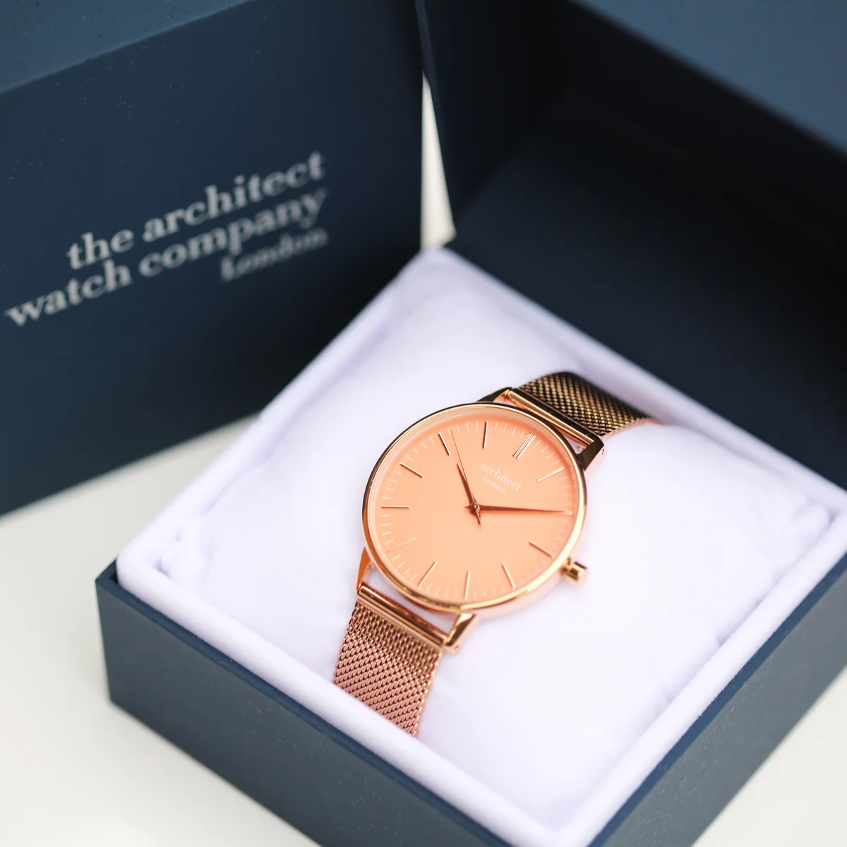 Ladies Architēct Coral quartz movement watch with apricot coral dial and rose gold mesh strap on white background