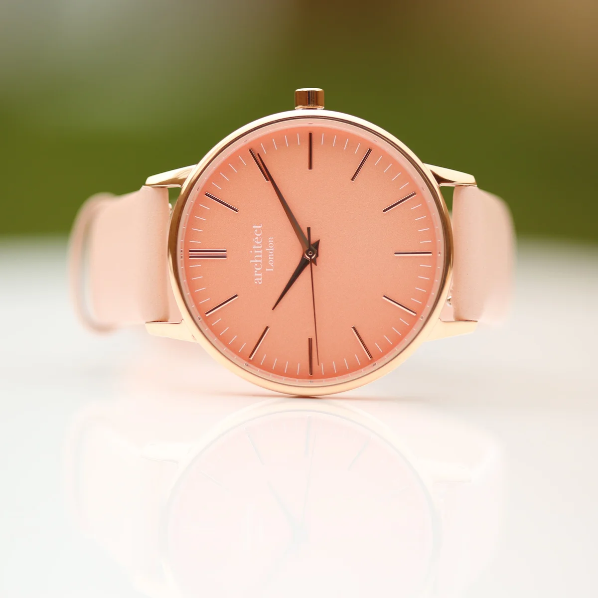 Ladies personalised watch with apricot coral dial, light pink leather strap, and stainless steel case on white background