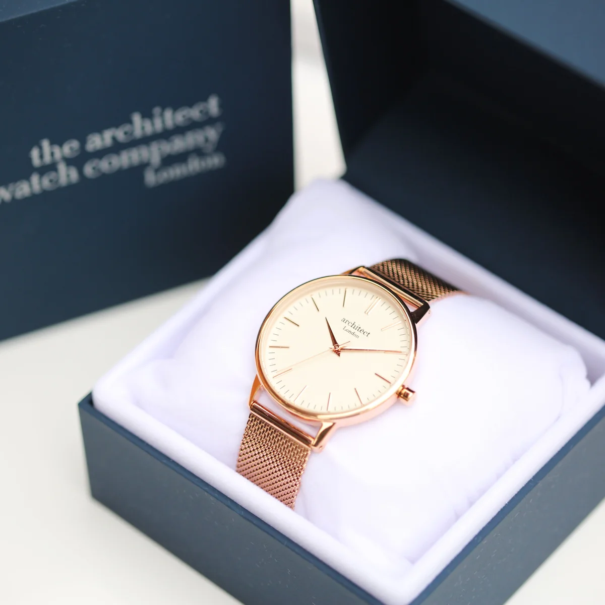 Ladies Architēct Blanc watch with modern font engraving and rose gold mesh strap on white background