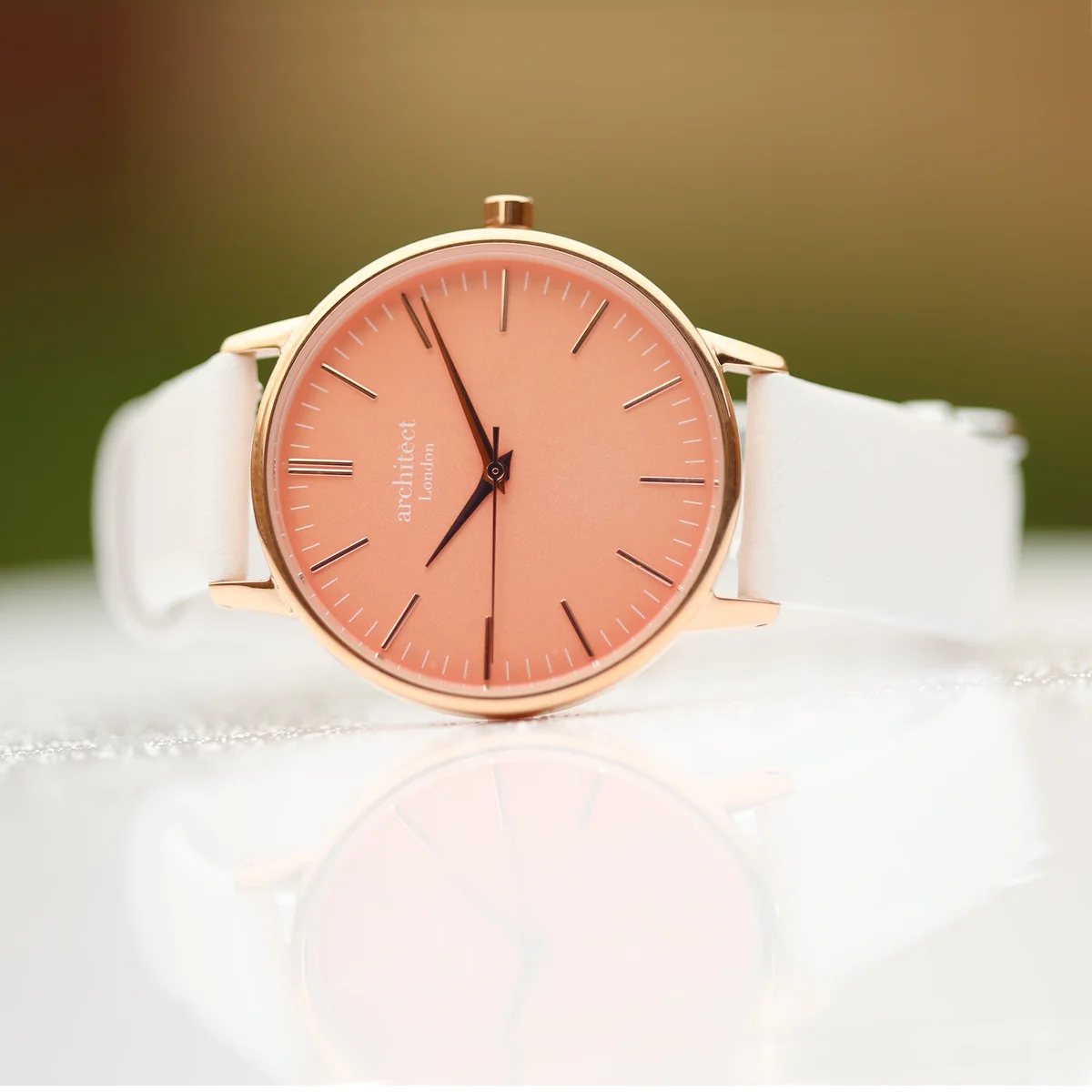 Personalised ladies watch with apricot coral dial, modern font engraving, polished stainless steel case, and white leather strap