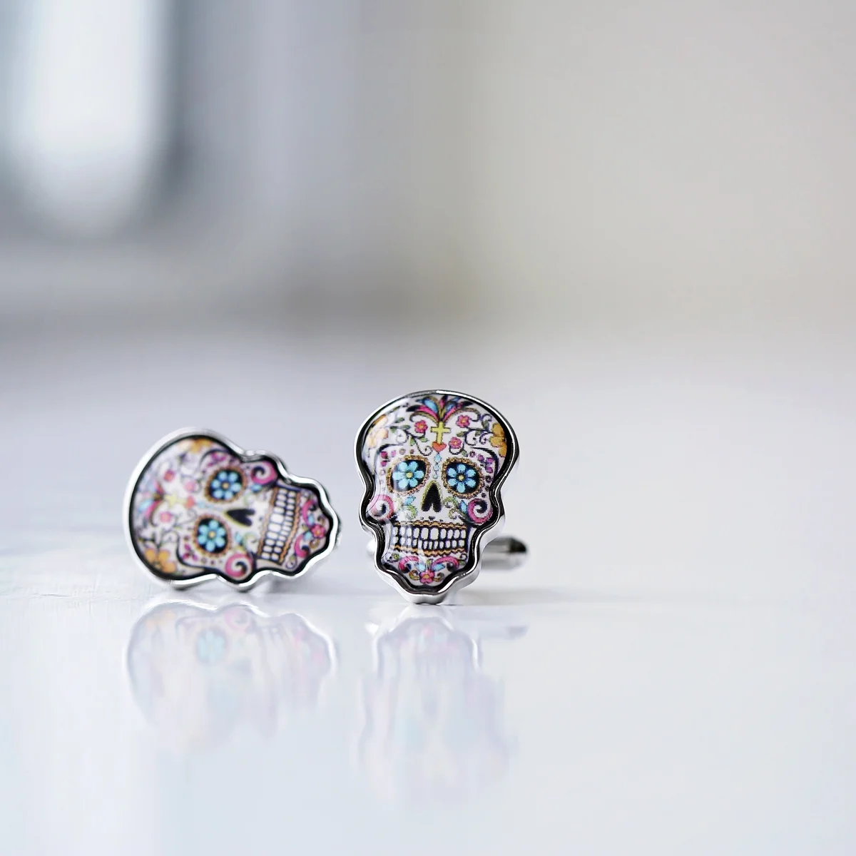 Colourful skull cufflinks displayed next to a luxury engraved box with personalised message on the lid