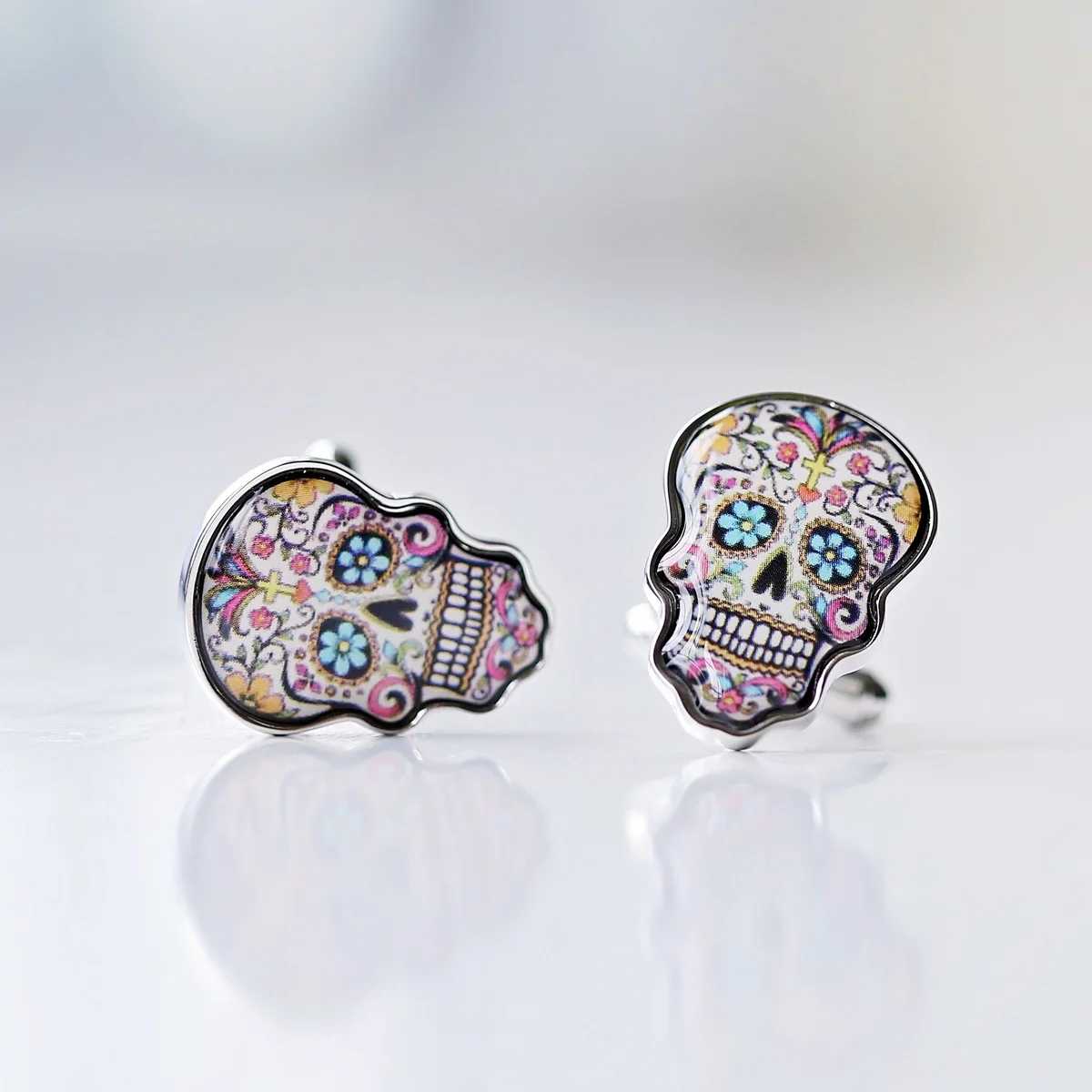 Colourful skull cufflinks displayed next to a personalised engraved cufflink box with custom message engraving
