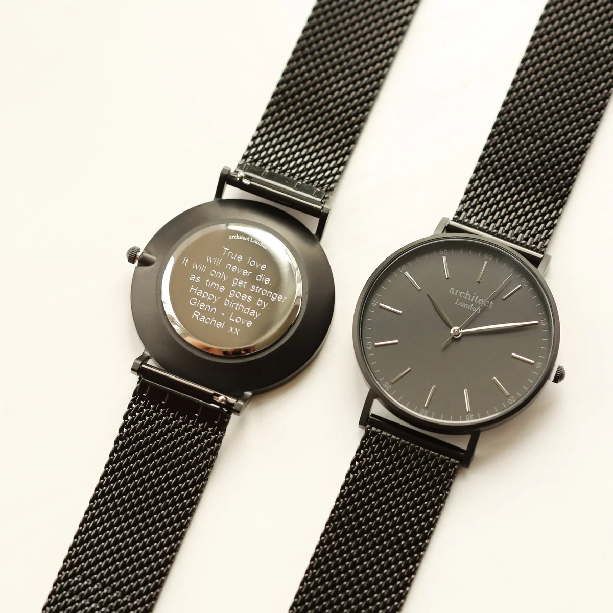 Men's minimalist watch with pitch black mesh strap, brushed stainless steel case, and modern font engraving option