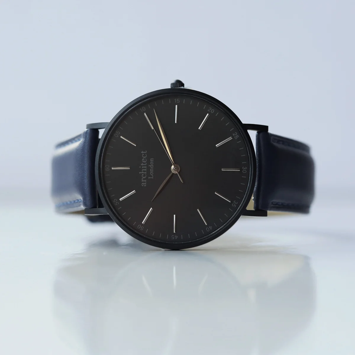 Minimalist men's leather strap watch with admiral blue genuine leather and brushed stainless steel case on white background