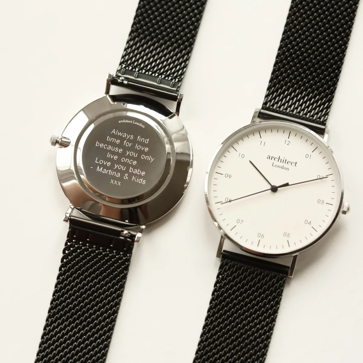Personalised men's watch with polished stainless steel case, black mesh strap, and minimalist white dial with modern font engraving