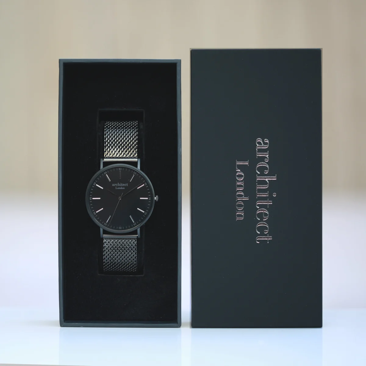 Men’s minimalist watch with pitch black mesh strap and stainless steel watch case shown on white background