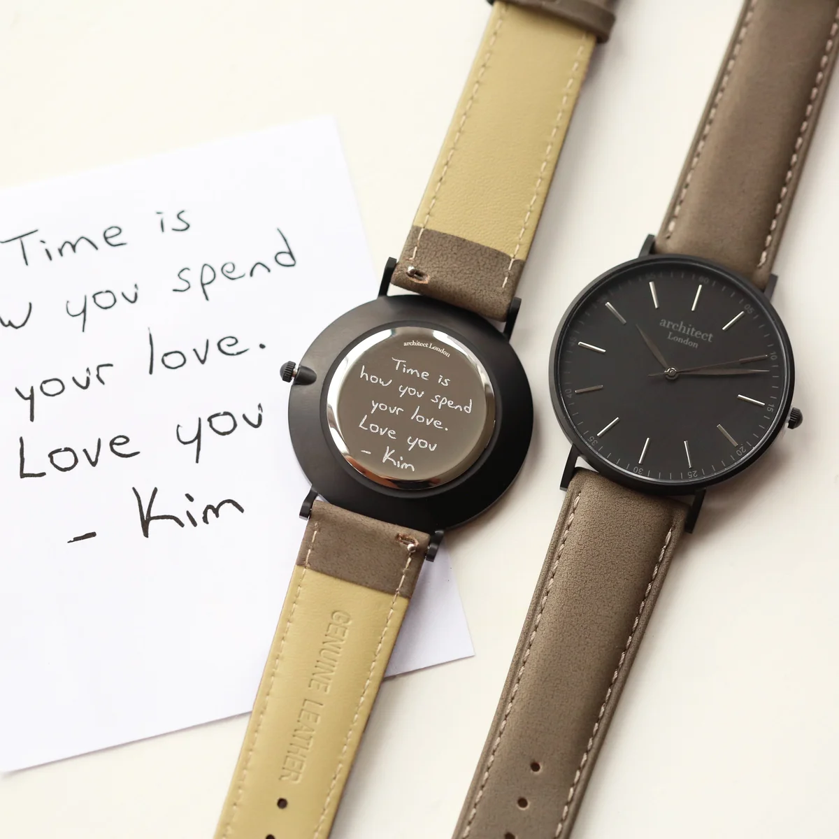 Personalised men's watch with minimalist grey leather strap and stainless steel case on white background