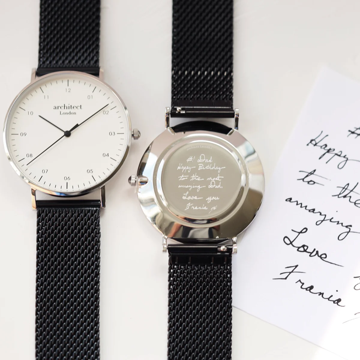 Personalised men's watch with black mesh strap, stainless steel case, minimalist dial, and custom handwriting engraving on back