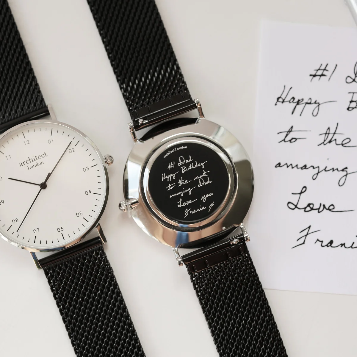 Men’s minimalist black mesh strap watch with polished stainless steel case and clear dial on white background