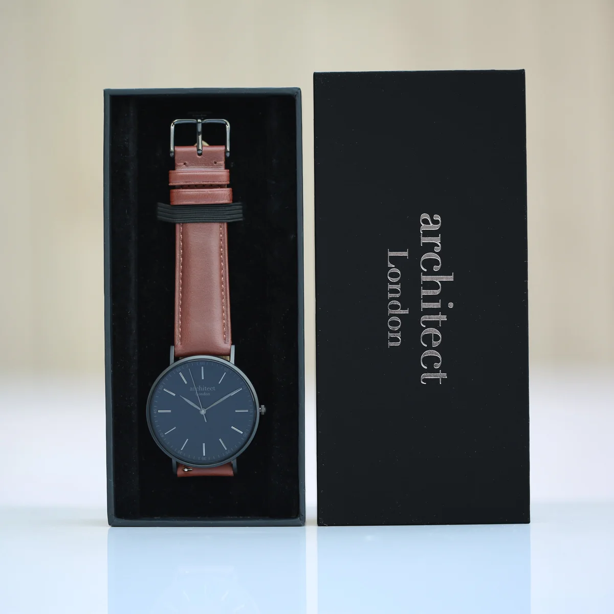 Men’s minimalist watch with walnut leather strap, stainless steel case, and engraved back shown in luxury box