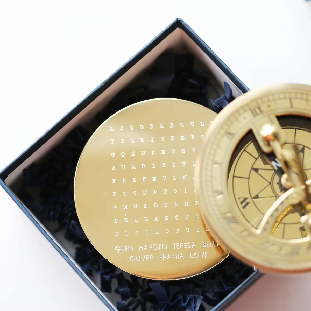 Engraved brass compass with hidden personalized words, nautical sundial design, shown with protective pouch and gift box