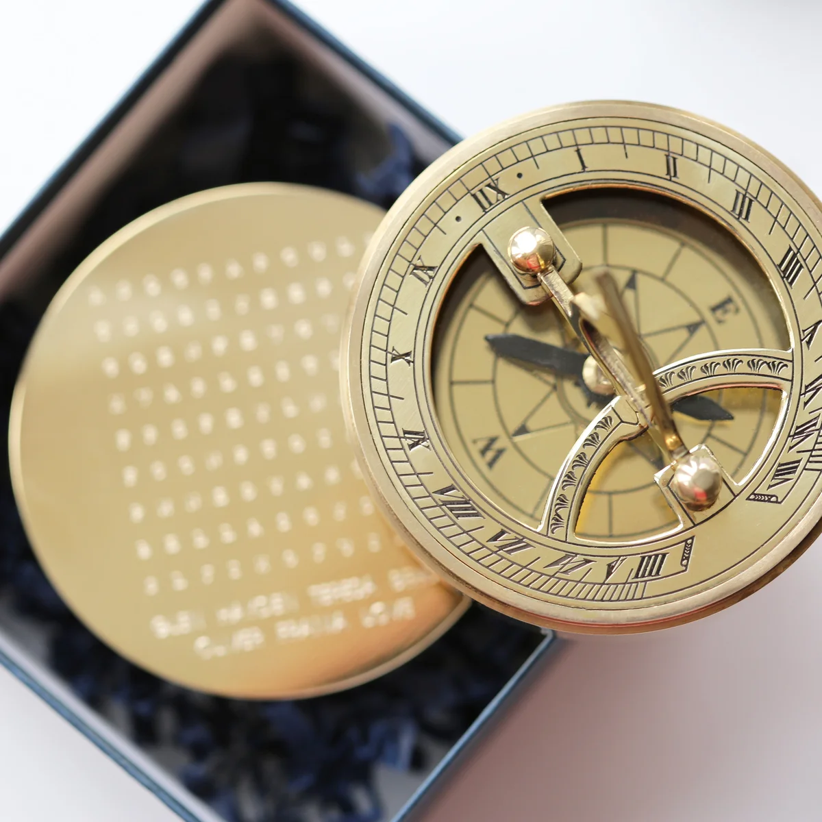 Brass nautical sundial compass with hidden engraved words, shown with protective pouch, a custom word search gift in a gift box