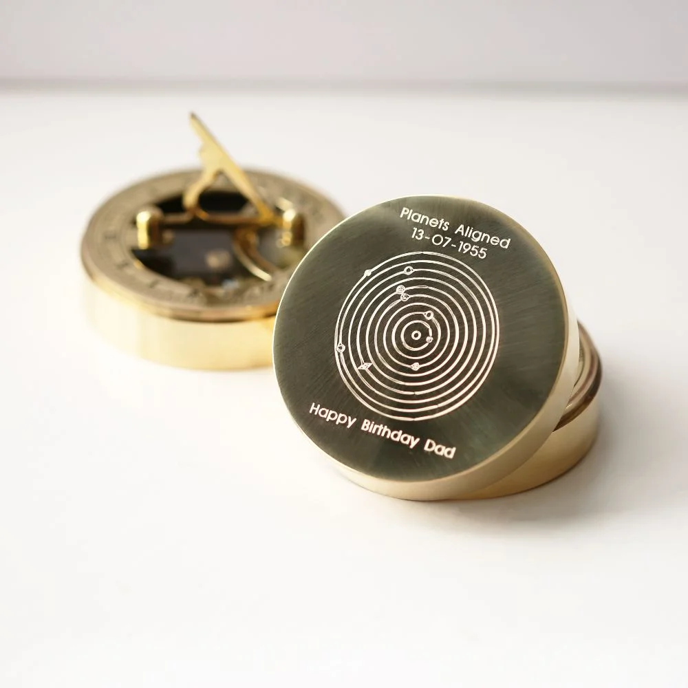 Brass nautical sundial compass with engraved date compass and planets aligned design, shown with protective pouch and gift box