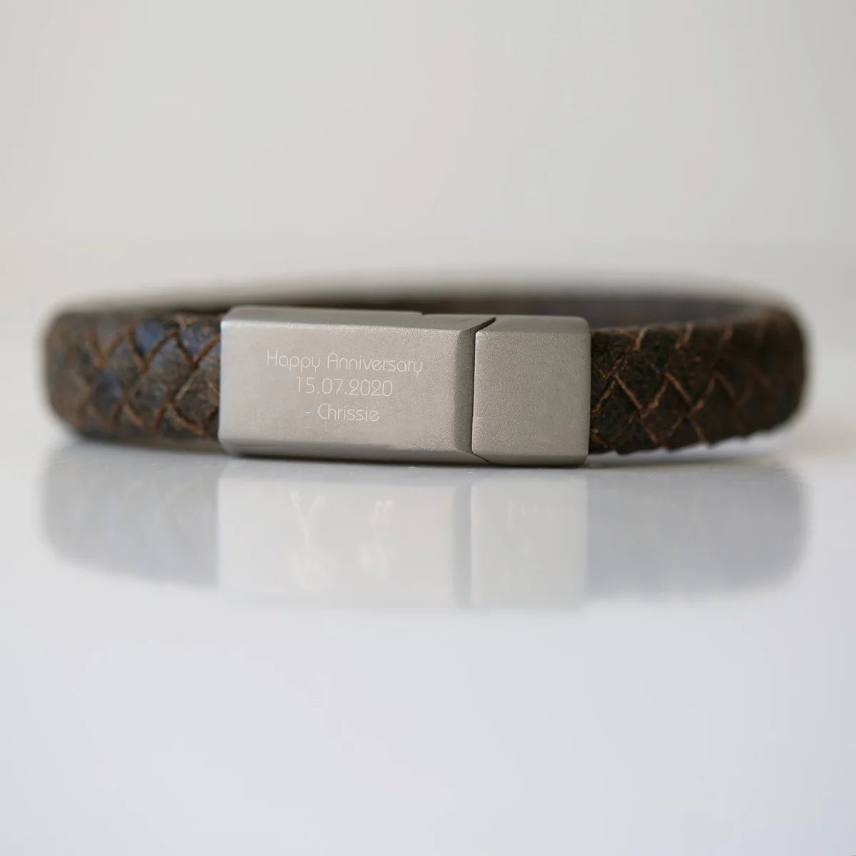 Rustic personalised leather bracelet with woven genuine leather strands and magnetic snap-lock clasp on white background