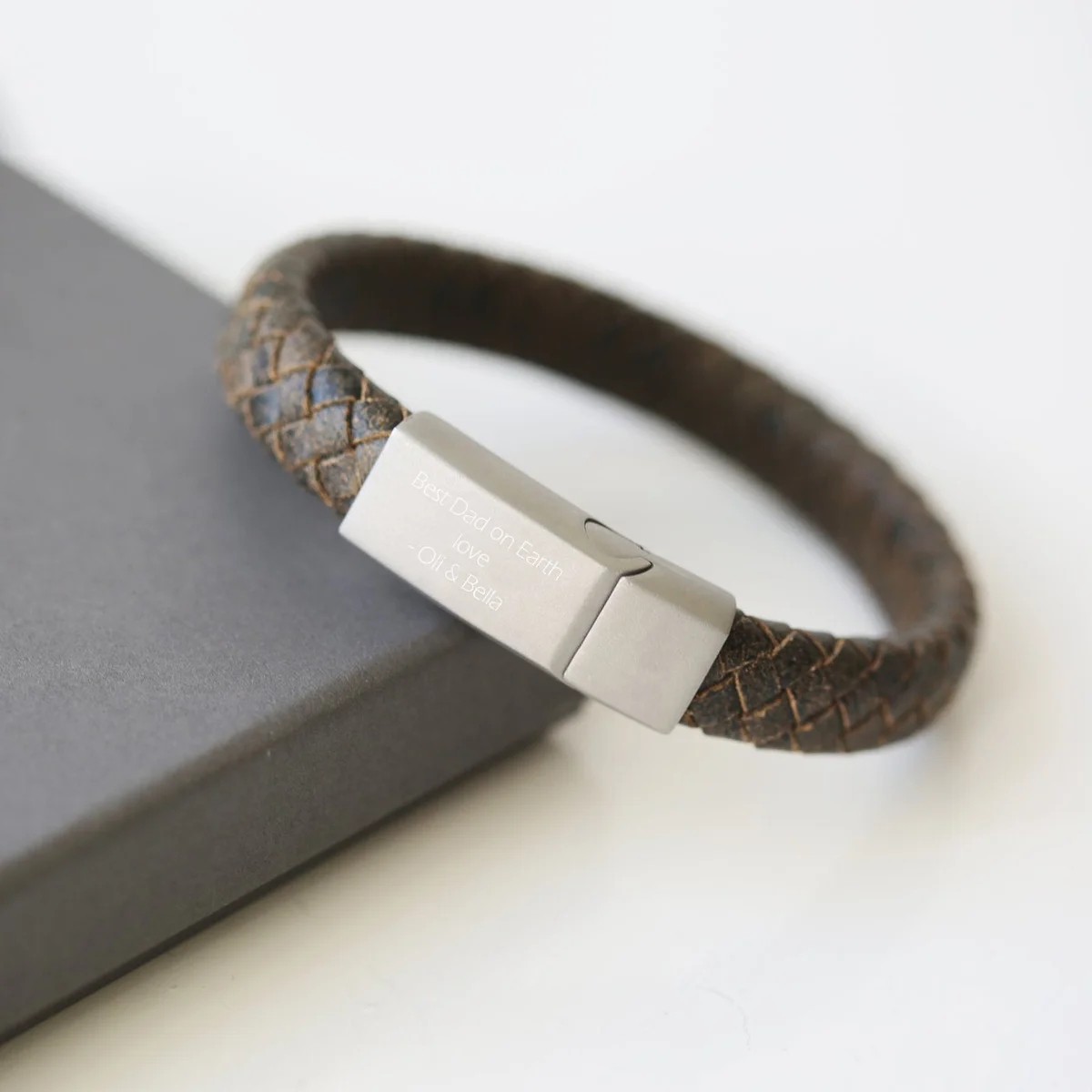 Rustic engraved leather bracelet with woven genuine leather strands and magnetic snap lock clasp on white background
