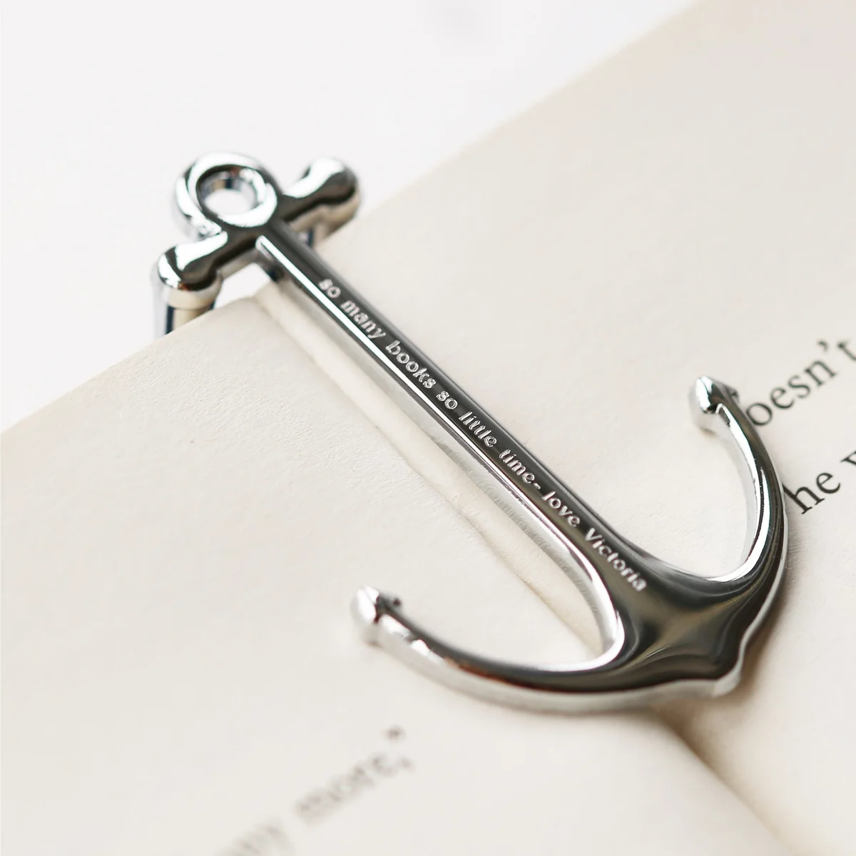 Silver and black metal book anchor holding open a book, polished finish with engraved personalised message, gift box included