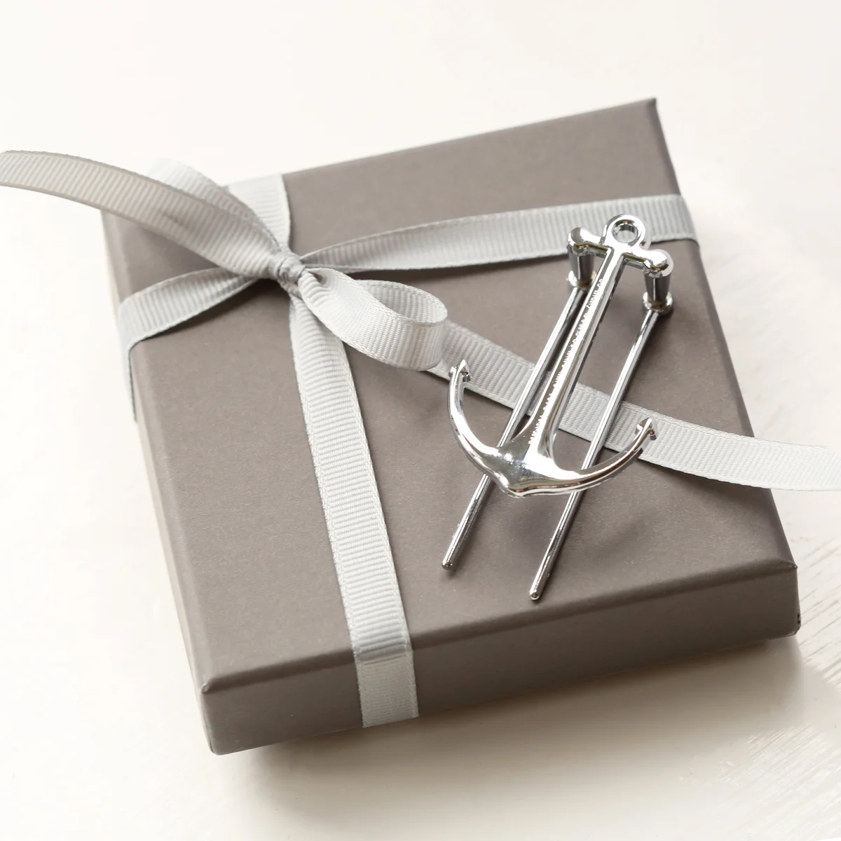 Silver and black polished metal book anchor with engraved message, ideal bookworm gift idea, shown with gift box