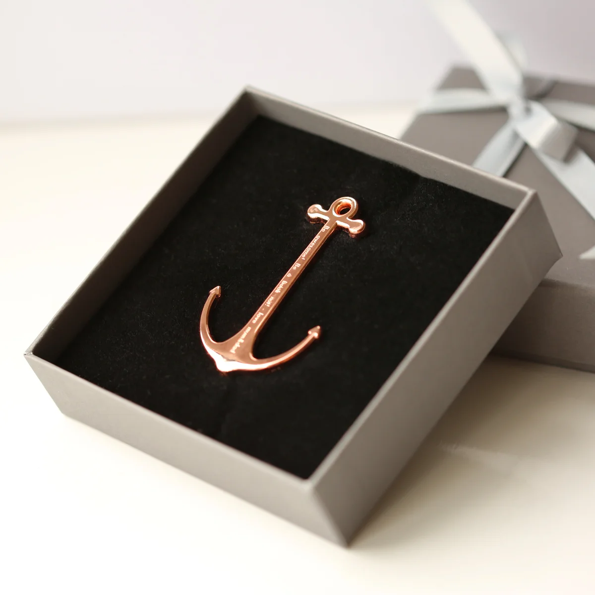 Gold and rose gold polished metal book anchor engraved, shown with gift box, a stylish book reading accessory for comfort
