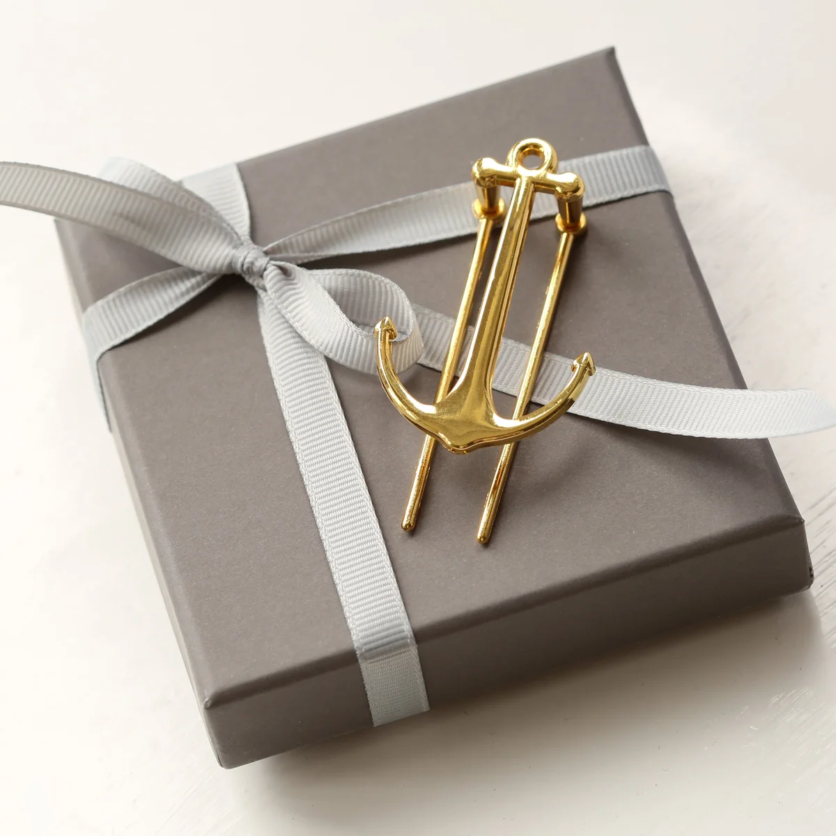 Gold and rose gold book holder with engraving, polished metal, holding open a book, displayed with gift box