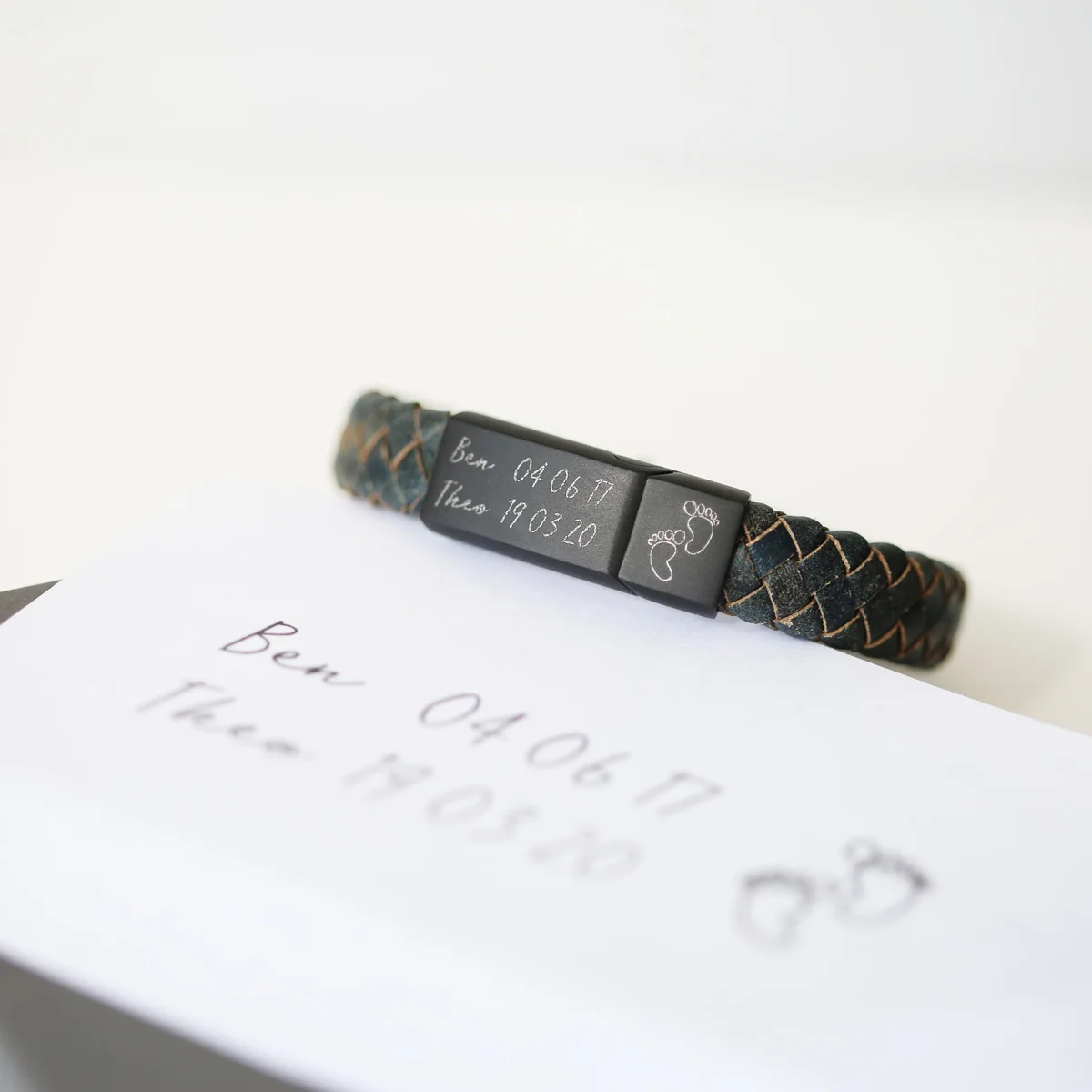 Iron-colored genuine leather engraved handwriting bracelet with magnetic snap clasp on white background
