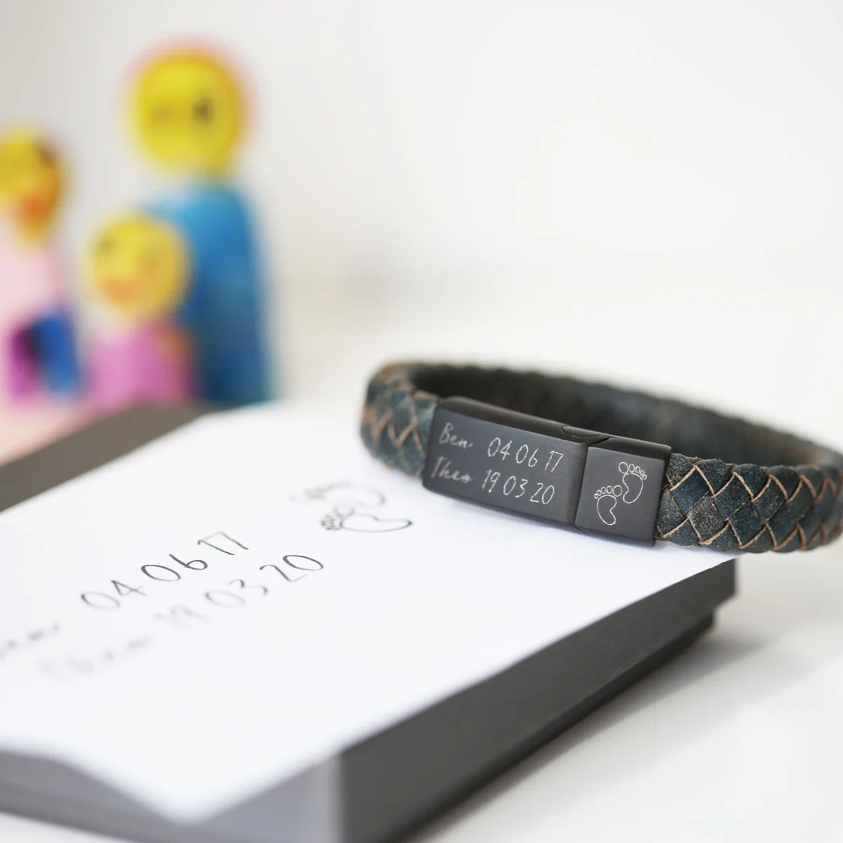Custom engraved bracelet in iron with genuine leather woven strands and magnetic snap-lock clasp on a white background