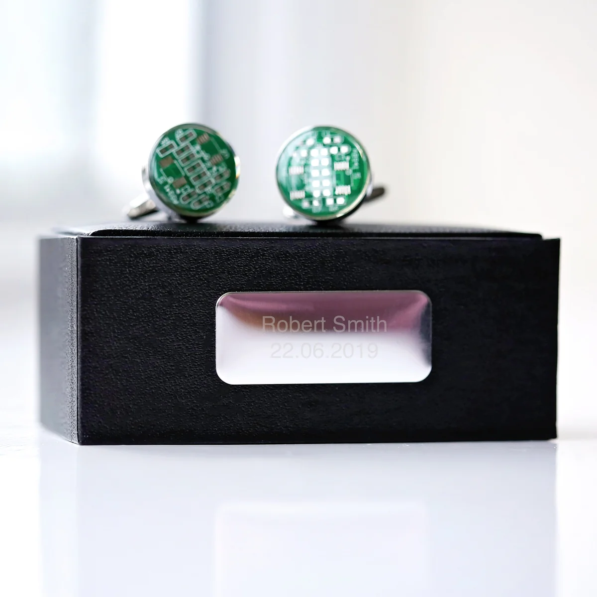 Pair of real circuit board cufflinks displayed with engraved luxury box on a white background