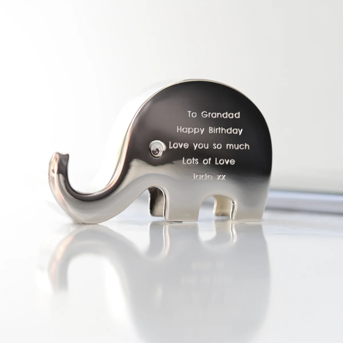 Engraved stainless steel phone stand shaped like an elephant holding a phone on its trunk, polished finish, 7cm tall