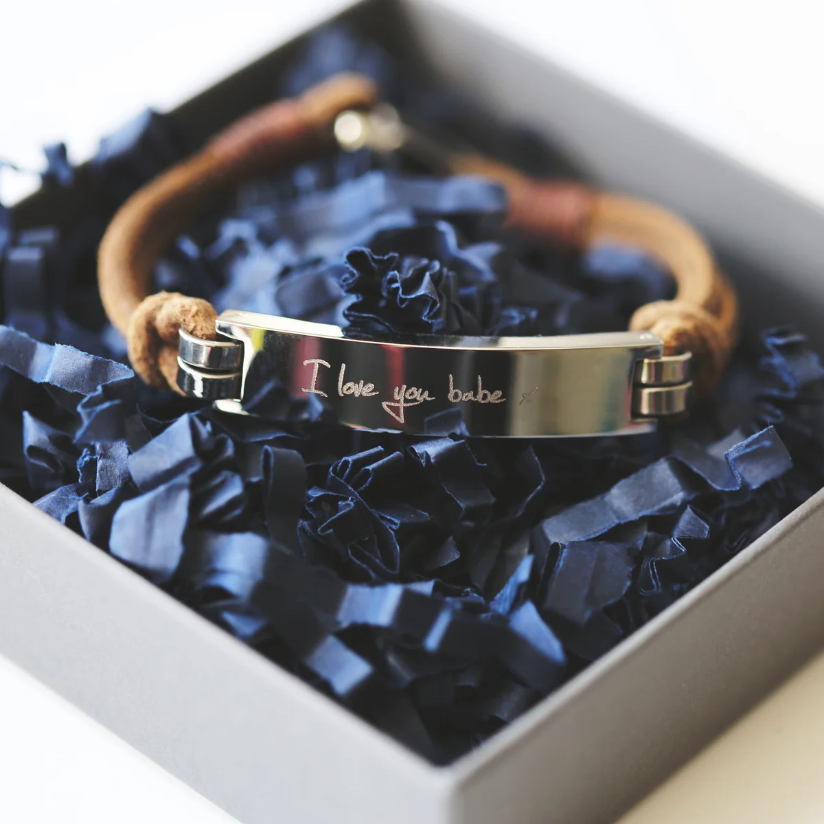 Tan genuine leather men's leather bracelet with engraved handwriting and snap-lock clasp on a white background