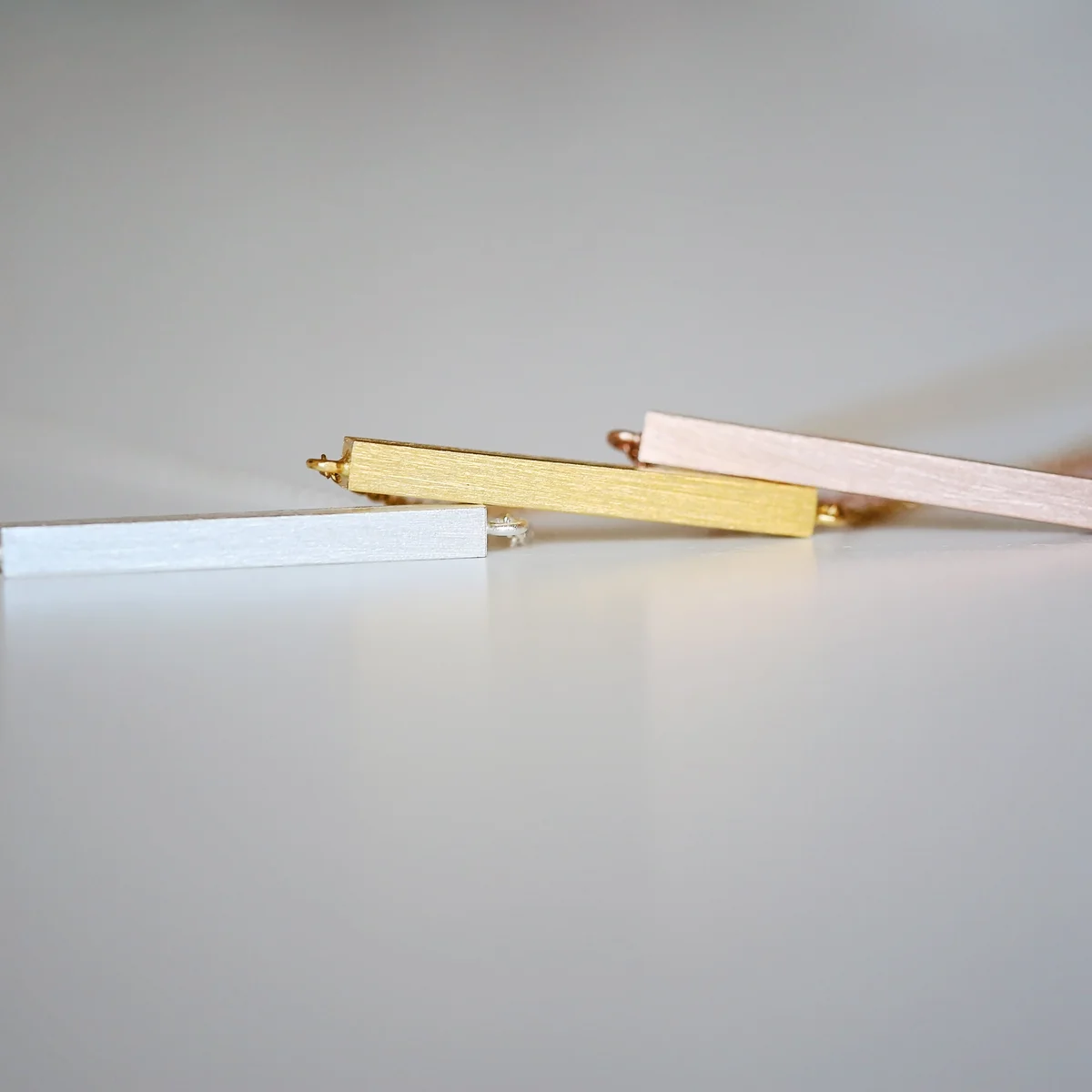 Gold necklace with a horizontal engraved bar pendant on a 49cm adjustable chain, displayed on a white background