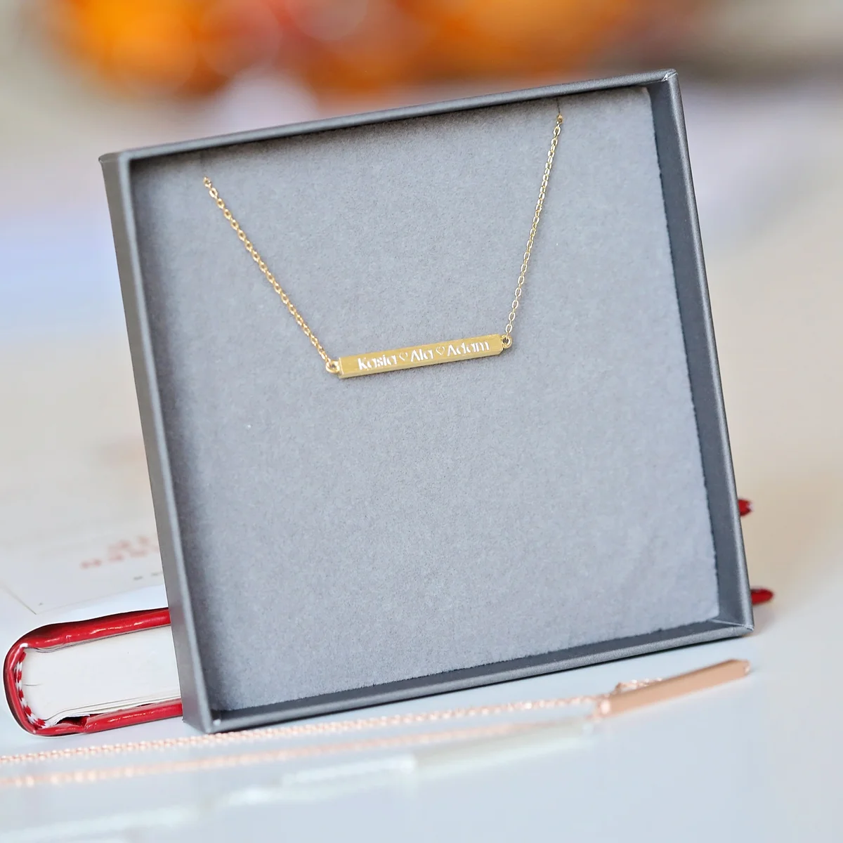 Personalised engraved horizontal necklace in rose gold with adjustable chain necklace on a white background