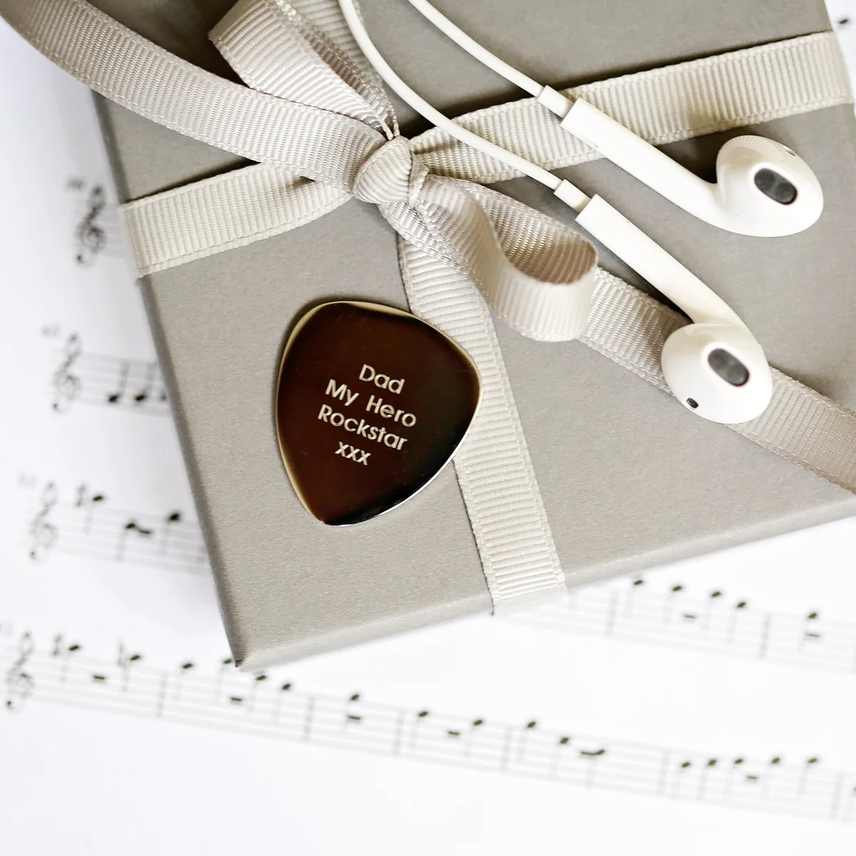 Custom guitar plectrum engraved with modern font, polished stainless steel in gift box with blue zig-zag shred and satin ribbon