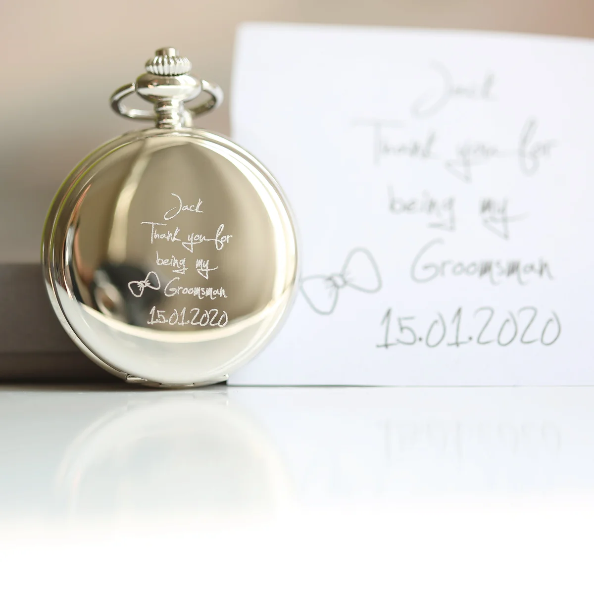 Handwriting engraved roman numeral pocket watch with skeleton view showing mechanical inner workings on white background