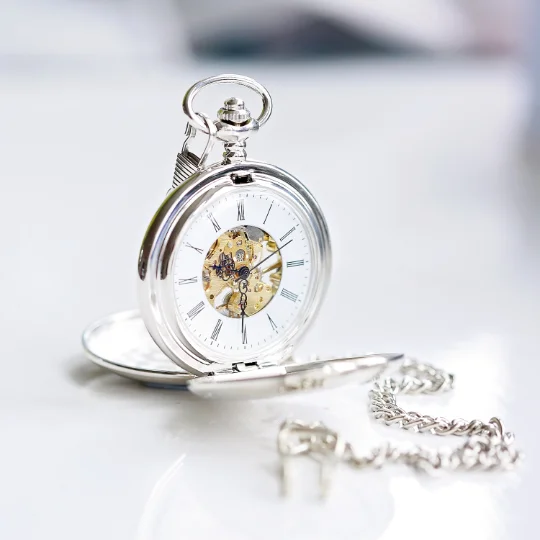 Dual opening pocket watch showing engraved front and back with visible mechanical skeleton movement inside.