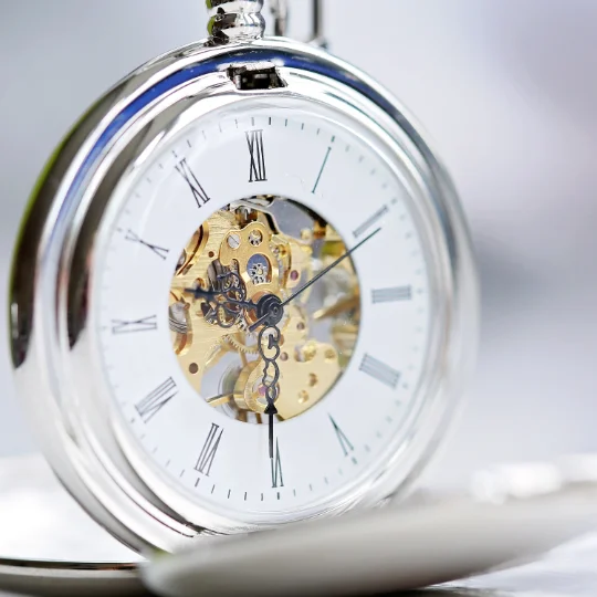 Open skeleton gift pocket watch showing mechanical movement and personalised handwriting engraving on front and back covers