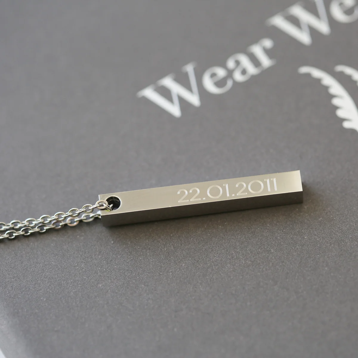 Personalised bar necklace in silver with modern engraved font on a delicate rectangular pendant on a chain