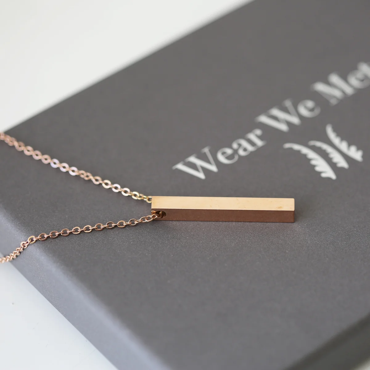 Gold bar necklace with delicate modern engraving, displayed on a soft background, includes a gift box from Wear We Met