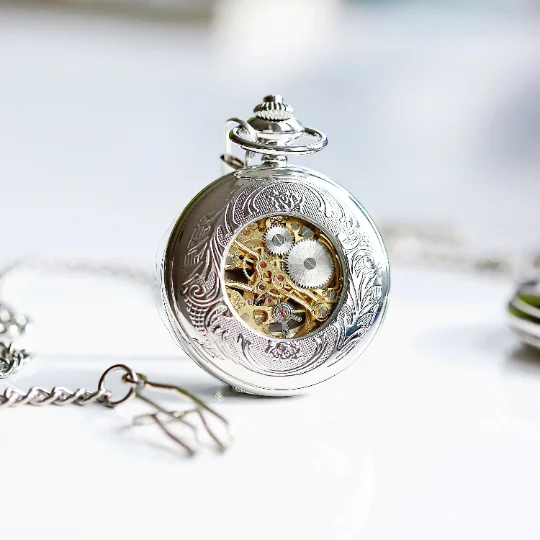 Personalised skeleton pocket watch with Roman numerals, visible mechanical movement, silver case, and engraved message on cover