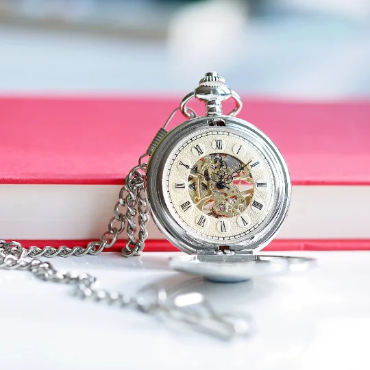 Open personalised roman numeral pocket watch showing skeleton movement and engraved cover in gift box with ribbon