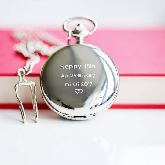 Personalised skeleton pocket watch with visible mechanical inner workings and Roman numeral dial in open silver case