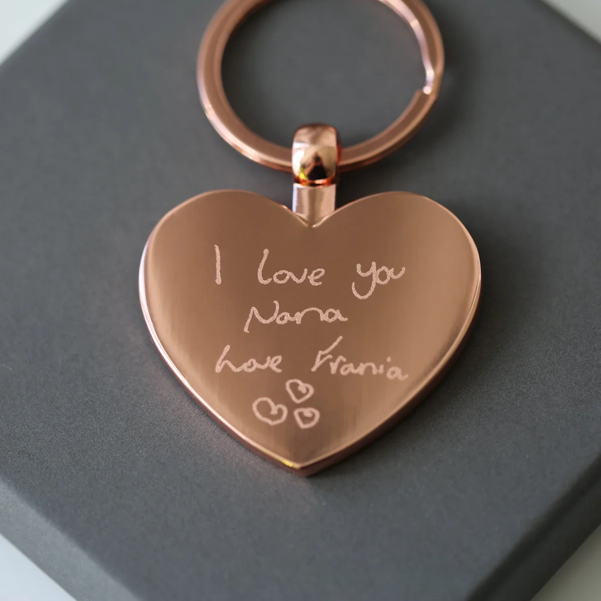 Hearts Forever keychain in polished stainless steel with unique handwriting gift engraving in silver, shown with gift box and blue shred