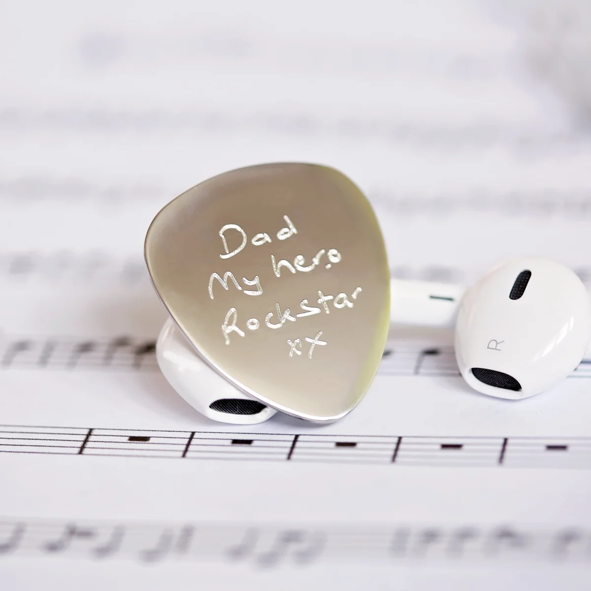 Personalised guitar pick engraved with handwriting on polished stainless steel in a gift box with blue zig-zag shred and ribbon