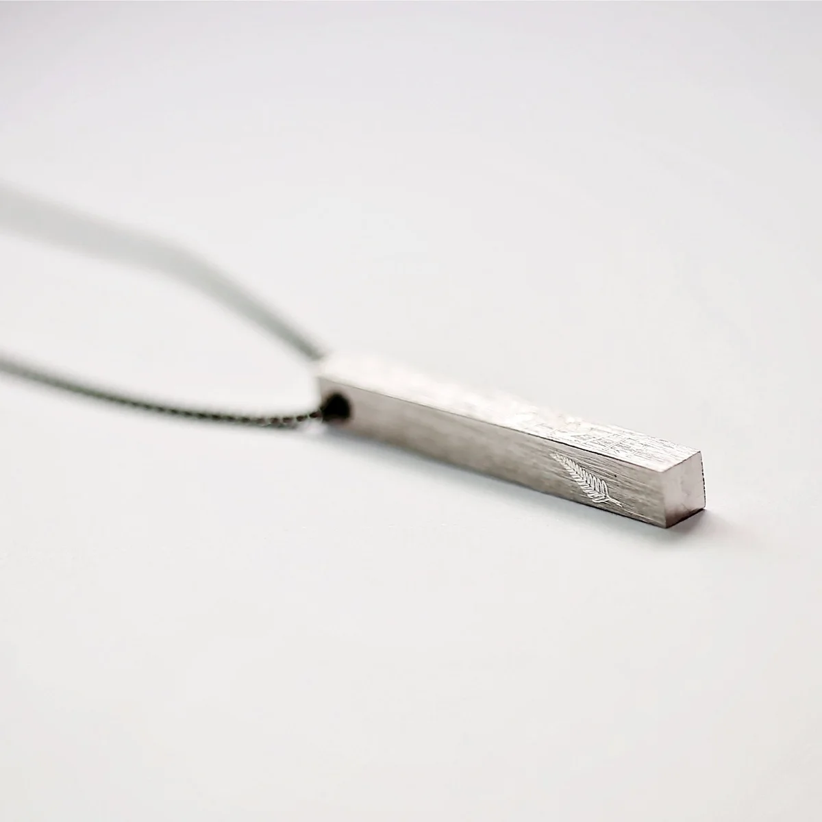 Brushed finish engraved men's necklace 30mm long displayed with Wear We Met gift box and blue zig-zag shred