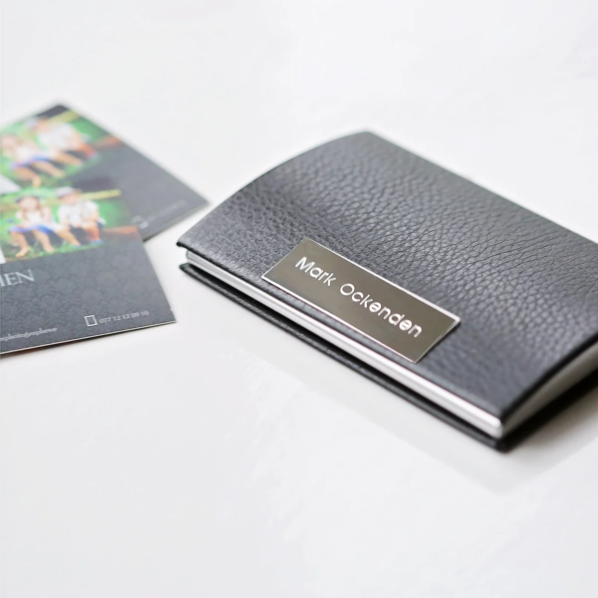 Polished stainless steel business card holder in black with engraved message, snap-lock magnetic closure, gift box included