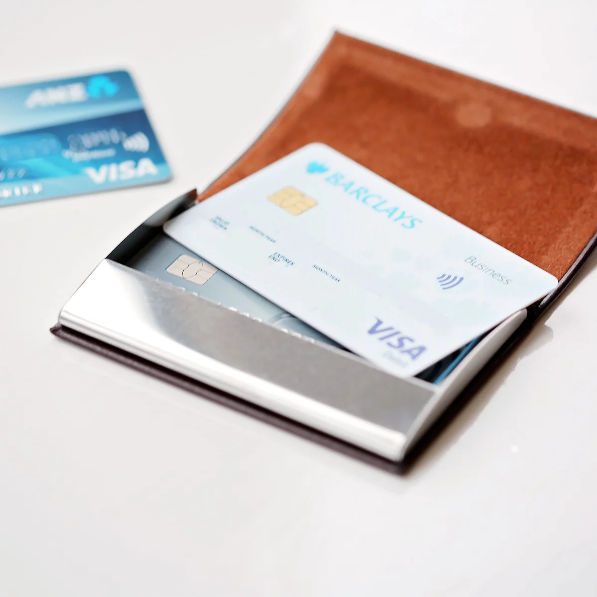 Personalised card holder in polished stainless steel with engraved message, snap-lock closure, shown with gift box and pouch