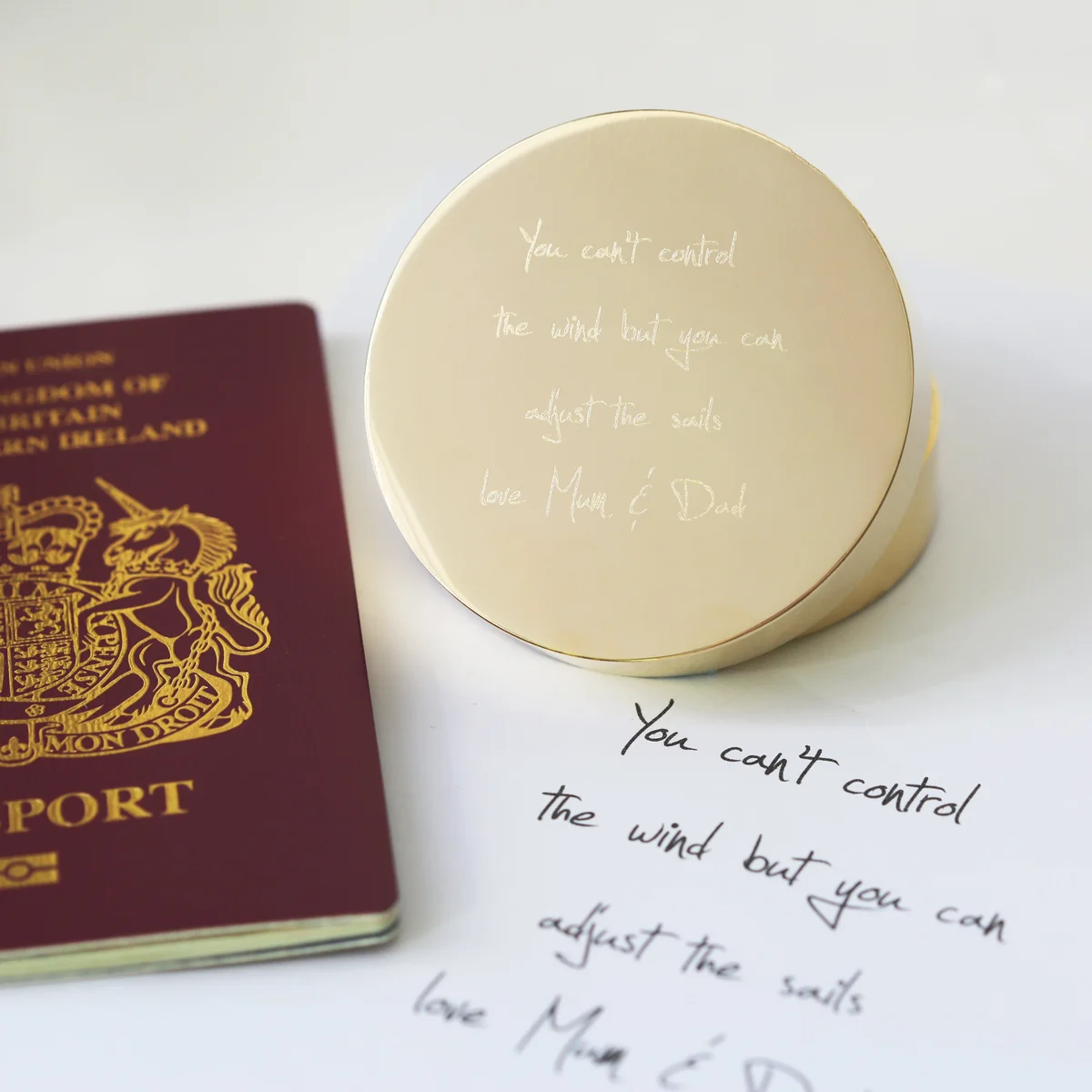 Personalised sundial compass with own handwriting engraving displayed next to its protective pouch and gift box with ribbon