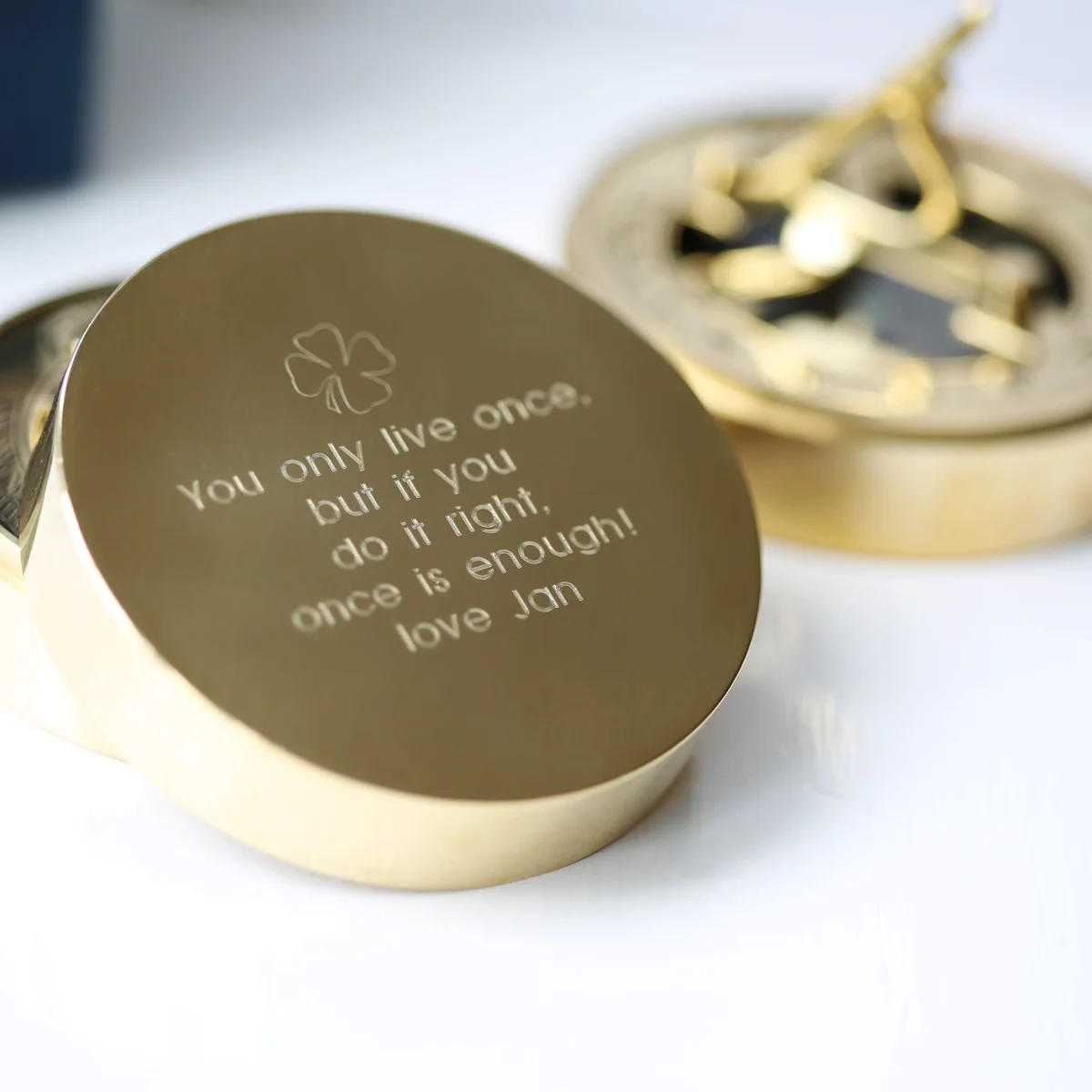 Personalised sundial compass in engraved brass with protective pouch and gift box on a white background