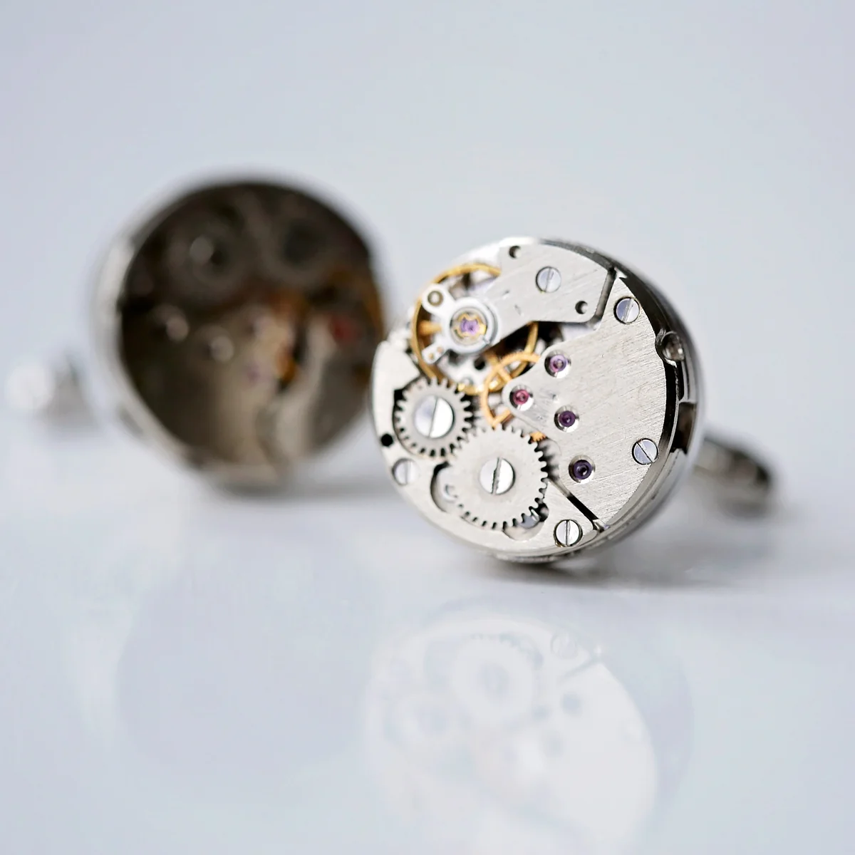 Pair of personalised cufflinks featuring intricate moving gear mechanisms in polished stainless steel design