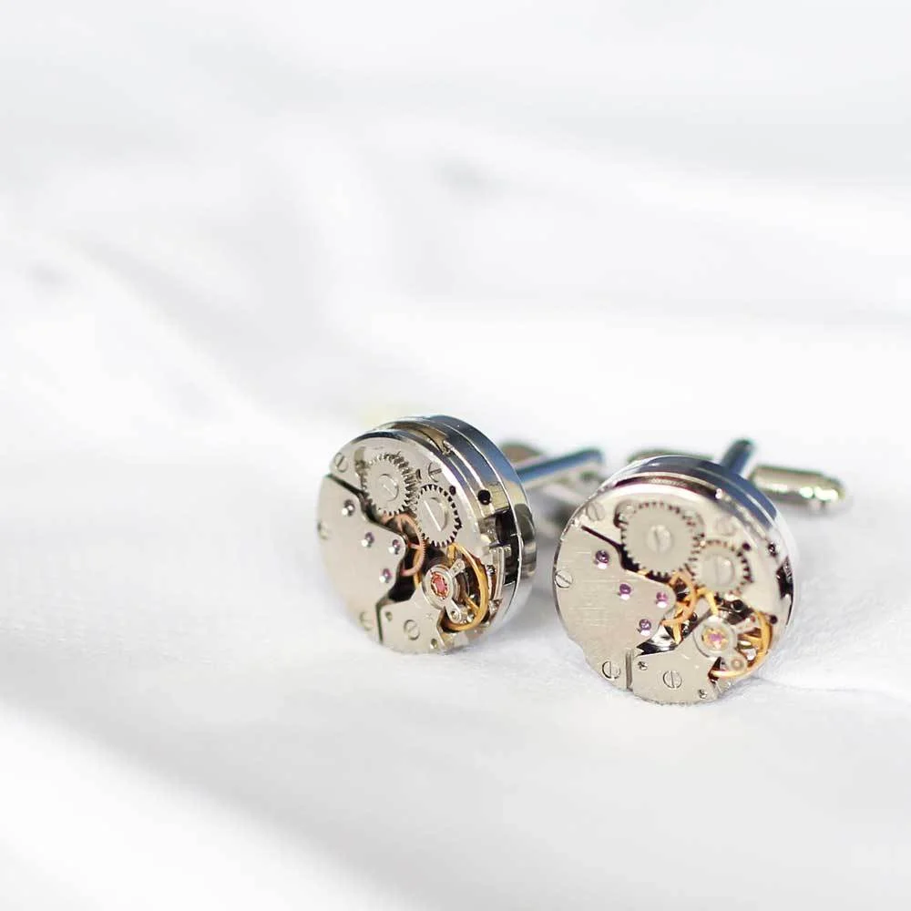 Close-up of engraved stainless steel moving parts cufflinks with visible tiny gears and intricate design