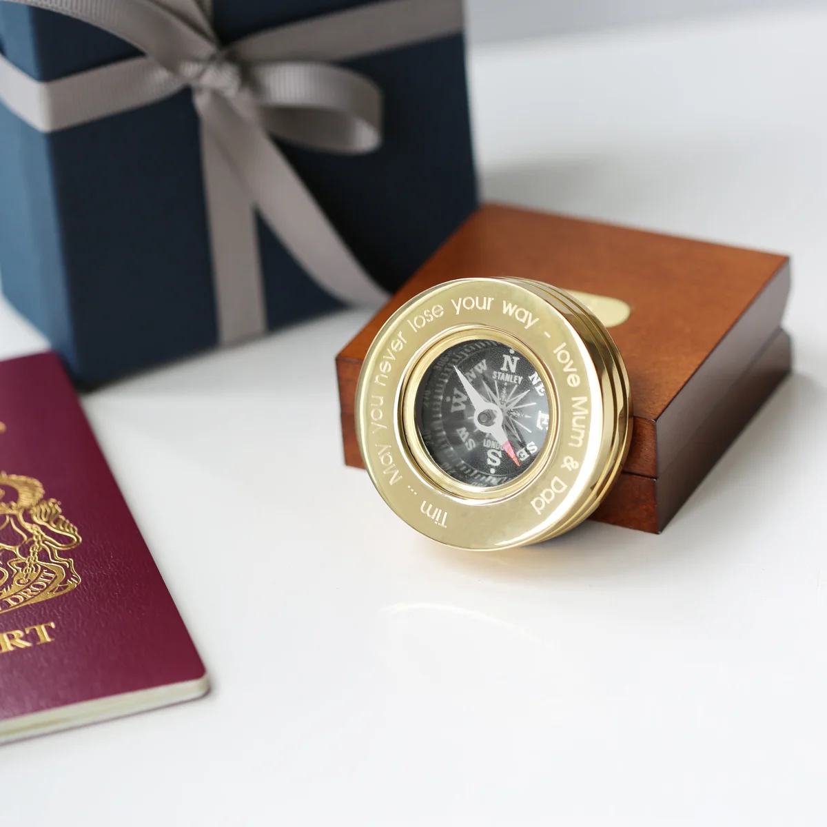 Personalised brass compass with modern font engraving inside a mahogany timber box with monogrammed metal plate and ribbon