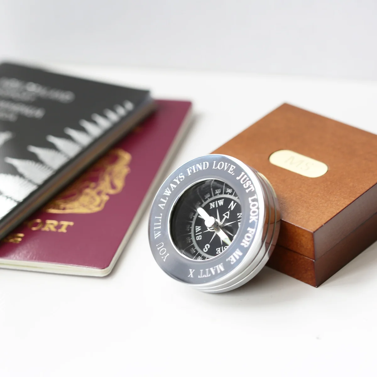 Personalised travel compass in brass with engraved modern font, displayed inside a polished mahogany timber box with monogrammed plate